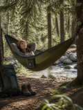 Nylon camping hammock hung between trees in a forest campsite