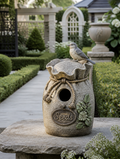 Decorative resin birdhouse in cottage garden