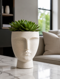 Abstract face planter on marble console table
