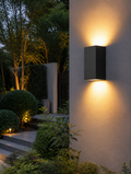 Waterproof LED wall sconce on garden wall at dusk