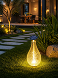 AquaOrb Solar Water Drop Lawn Lamp on garden lawn at dusk