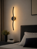 LED wall sconce beside bed headboard