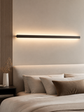 Long LED wall lamp above bed headboard