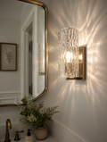 Water ripple glass wall sconce beside vanity mirror