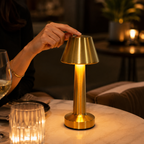 Gold rechargeable touch table lamp glowing on an upscale restaurant table