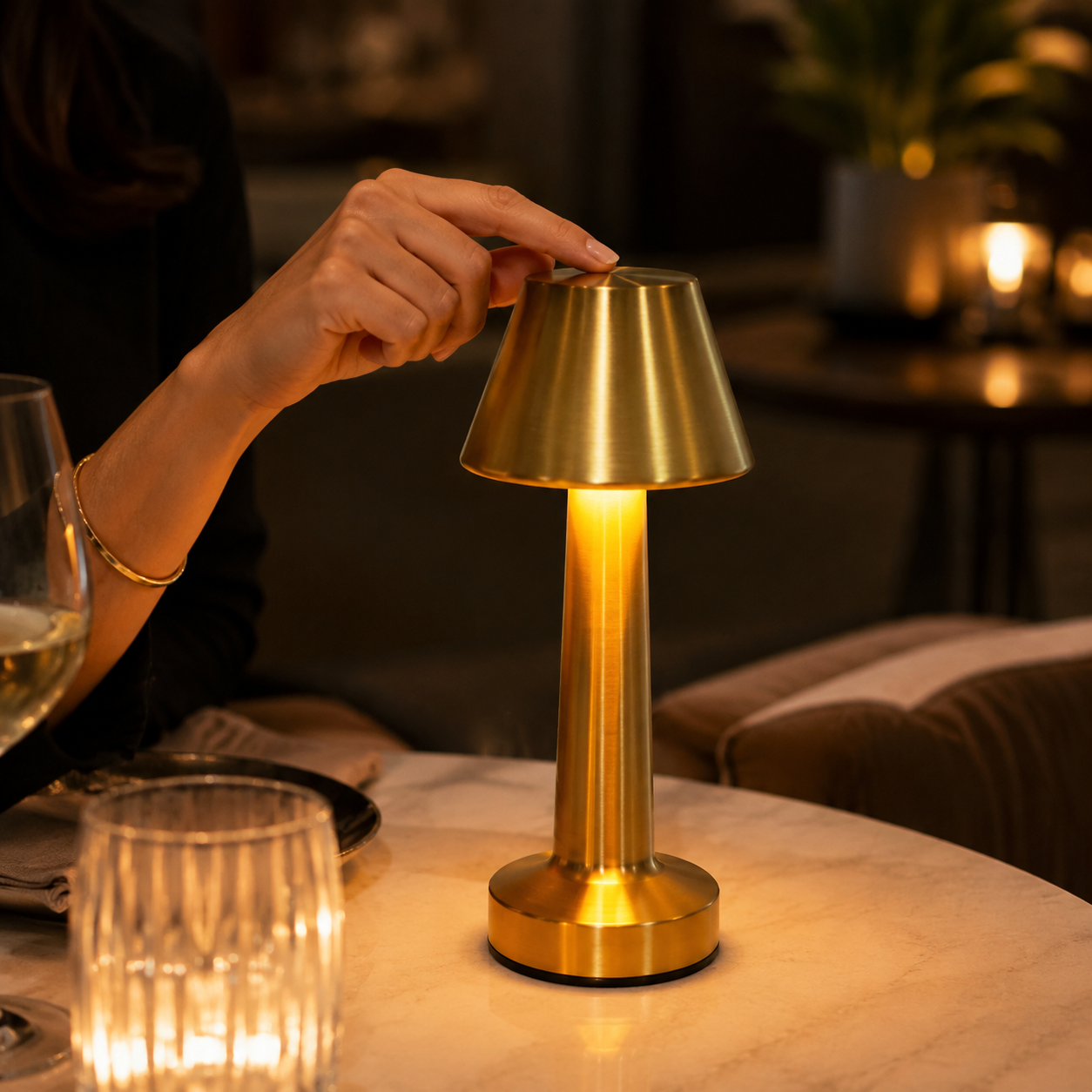 Gold rechargeable touch table lamp glowing on an upscale restaurant table