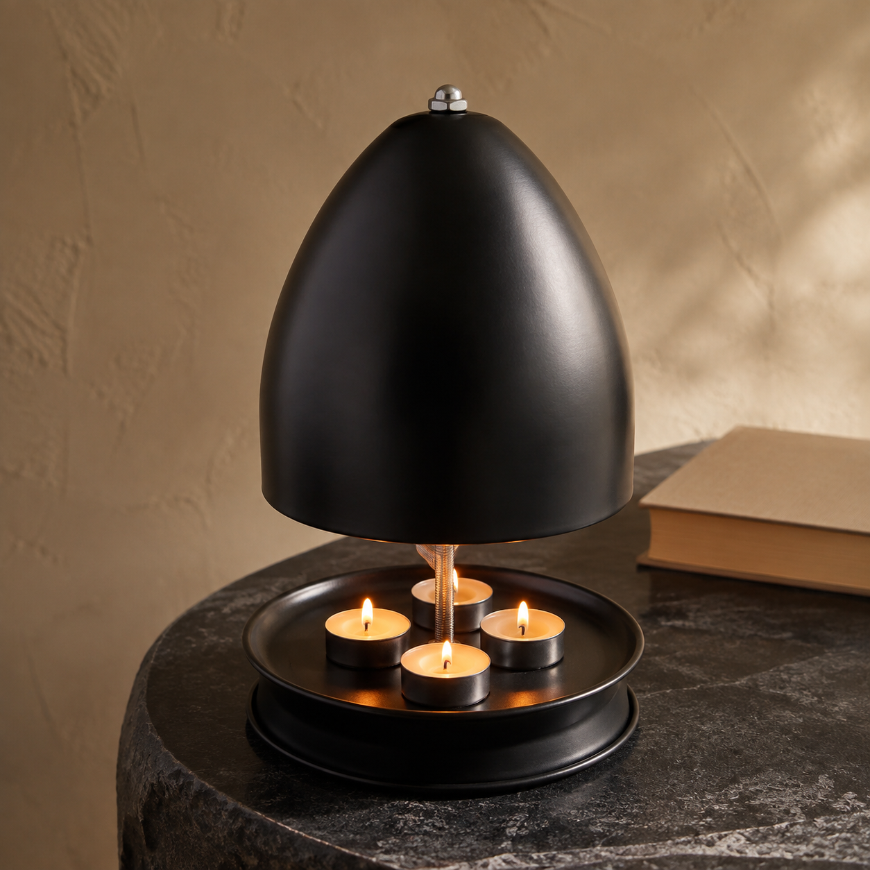 Black metal tea-light candle heater displayed on a heat-resistant stone table